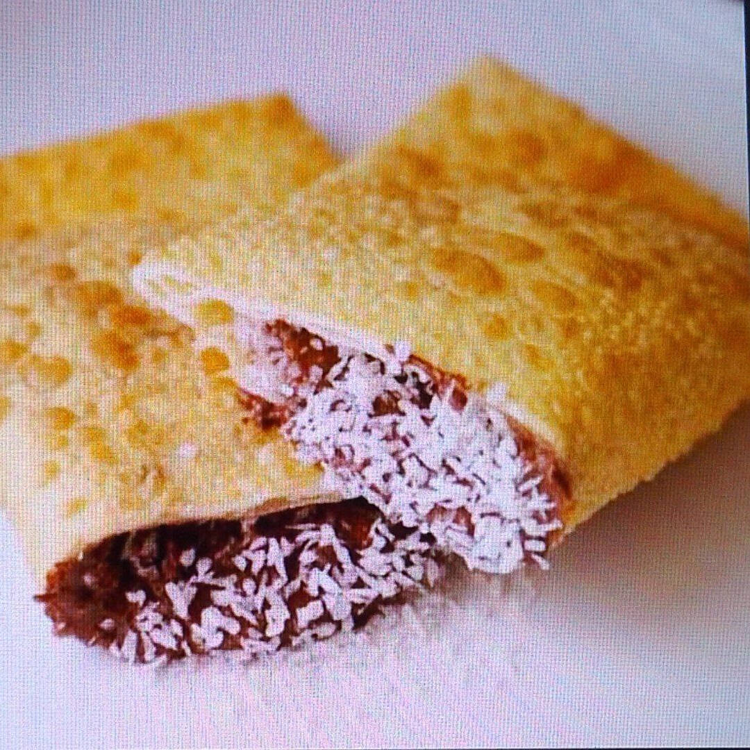 Pastel de Chocolate com Coco Ralado, feito com uma massa leve e crocante, recheado com chocolate cremoso e finalizado com coco ralado, trazendo aquele contraste perfeito entre doce intenso e frescor.