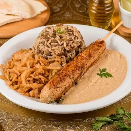 Suculenta kafta com arroz de lentilhas, cebolas crocantes, sua pasta árabe favorita e pão fresquinho. Um toque do Oriente no seu Dia!