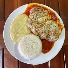 Deliciosa Parmegiana de Peixe, feito com o molho secreto da casa e mussarela gratinada, acompanhada de arroz soltinho e o melhor purê de batatas da sua vida.