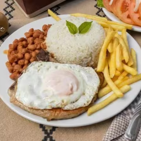 Bife de pernil grelhado com ovo frito, arroz soltinho, feijão temperado, salada fresca e sua escolha entre fritas crocantes ou farofa.