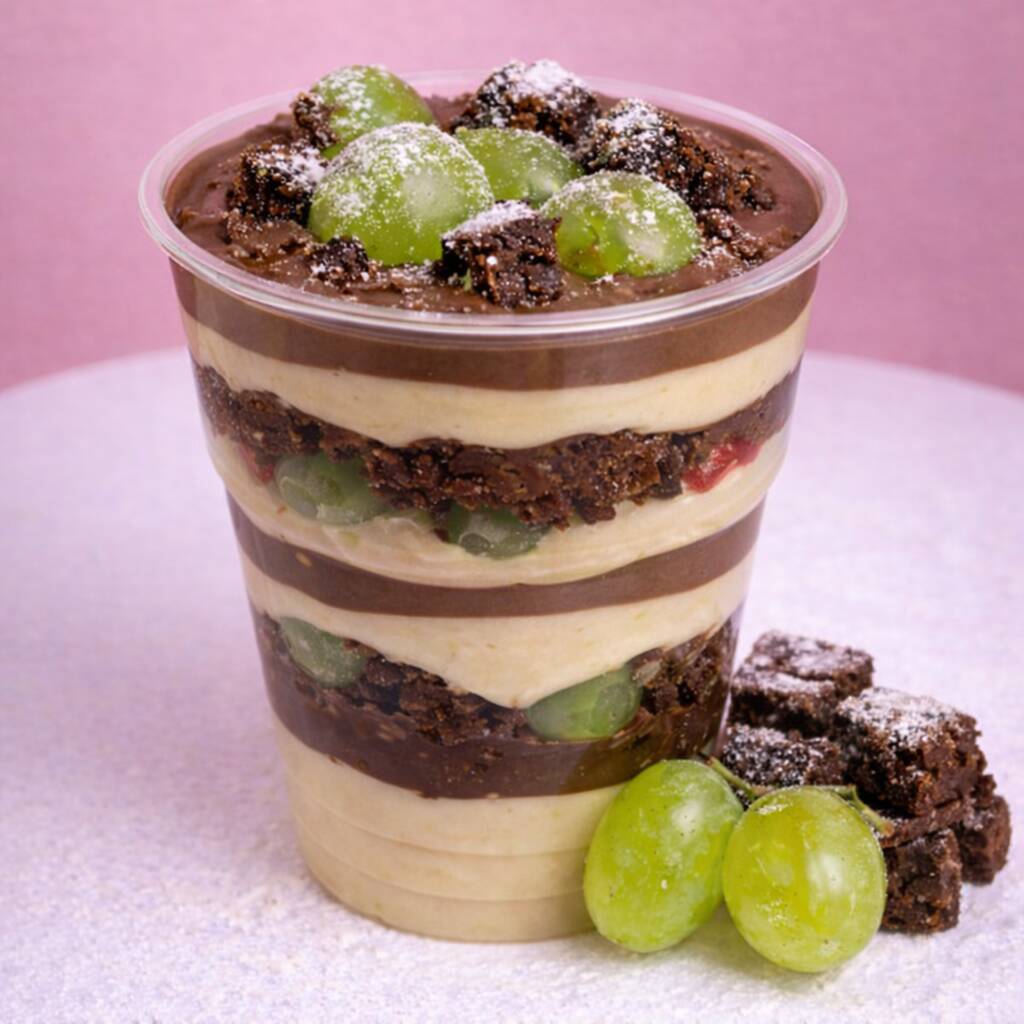 Camadas cremosas de mousse de ninho e mousse de chocolate intercaladas com brownie 350gartesanal macio e uvas frescas selecionadas. Finalizado com mais brownie e uvas por cima para uma explosão equilibrada entre cremosidade, intensidade e frescor. Uma sobremesa premium feita para impressionar.