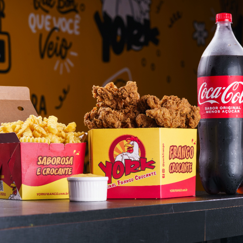 Você leva 1 Balde Box Frango Crocante Grande 900g + 1 Molho Artesanal da sua escolha + 1 Porção de 400g Batata Frita/ou Polenta/ou Mandioca + 1 Refrigerante 2l Coca-Cola/ ou Kuat Guaraná. Serve 3 a 4 pessoas. Foto ilustrativa.