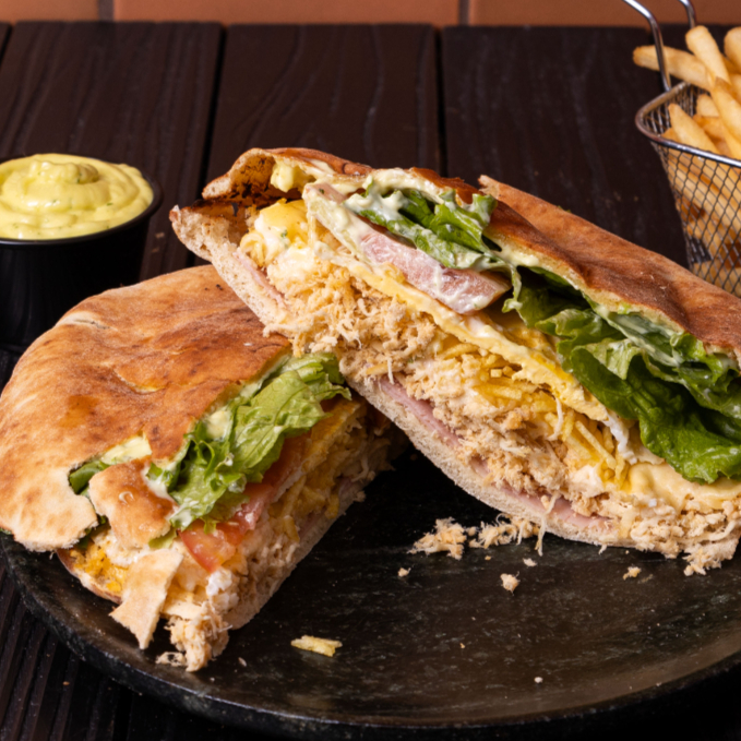 Beirute de Frango desfiado que faz muito sucesso aqui no Bedu. Feito para dividir, possui um Frango desfiado e temperado aqui na casa em seu generoso recheio e, para dar aquela cremosidade, adicionamos a nossa amada Maionese Bedu. Dentro dele ainda temos alface, tomate, ovo e batata-palha. Um verdadeiro matador de fome.