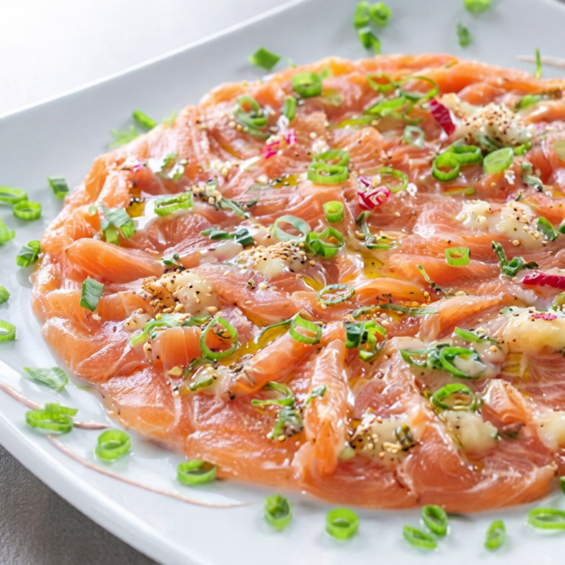 Delicioso carpaccio de salmão, com molho especial da casa, a base de gengibre, azeite, cebolinha, e especiarias