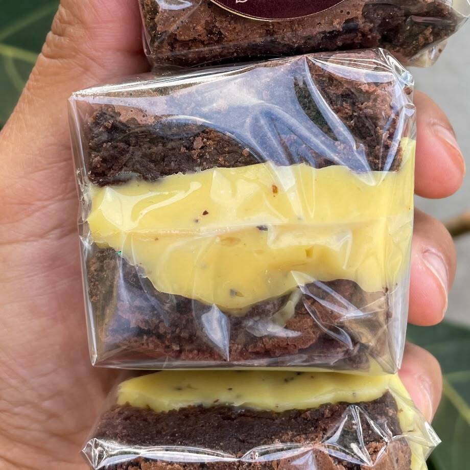 Brownie artesanal molhadinho e com uma casquinha crocante recheado com nosso brigadeiro maracujá cremoso. Serve até 1 pessoa (Aprox. 100g)