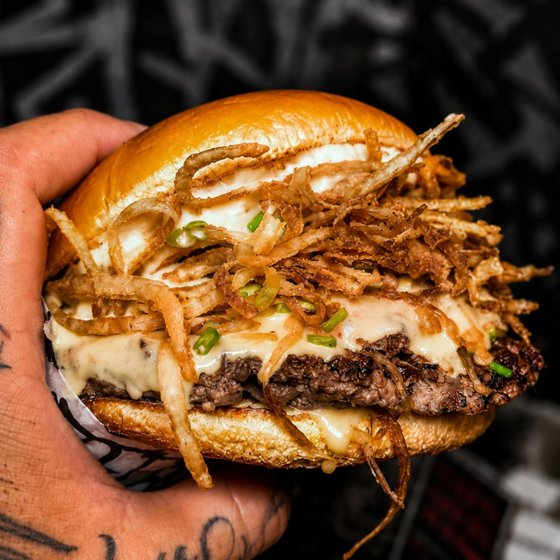 Nossa triade de cebola em um só burguinho, queijo cheddar, smash estilo oklahoma (bebola infundida), ceboal crispy, maionese de cebola caramelizada e cheiro verde!