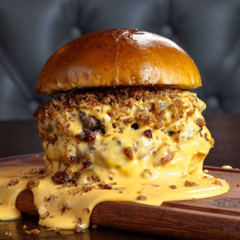 Pão brioche, 2 Blends Angus 100gr, Muiiiiitoo Creme de Cheddar, Muiiiitoo Bacon uma maionese da casa pra finalizar