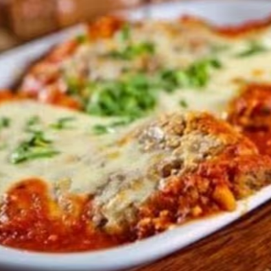Delicioso bife a parmegiana com arroz branco, feijão tropeiro, batata frita e vinagrete.