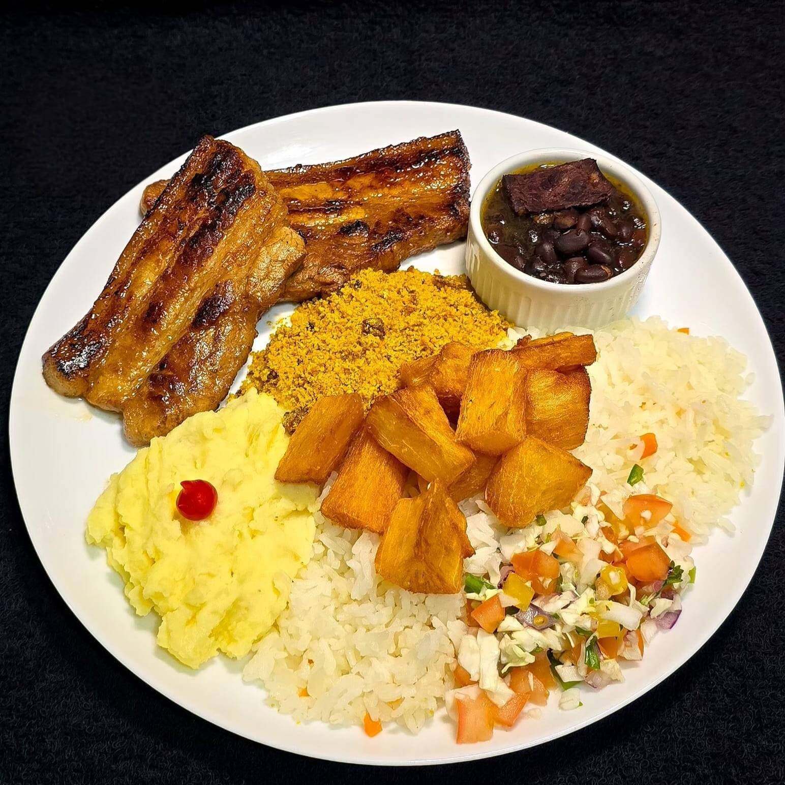 Deliciosos cortes de Carne Suína Especial passados na chapa (230g), acompanhados com arroz temperado caseiro, feijoada especial, farofa super crocante, macaxeira frita e vinagrete.
