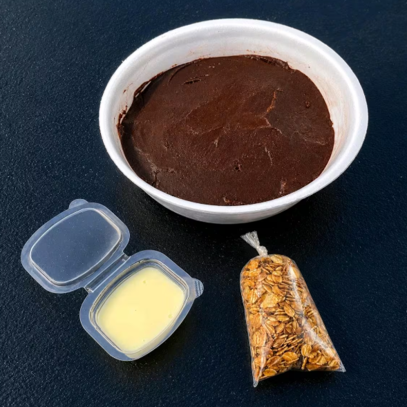 +02 acompanhamentos inclusos no seu pedido, enviados separadamente para preservar a crocância, cremosidade e qualidade de cada ingrediente. Assim você monta do seu jeito e aproveita uma experiência mais saborosa, organizada e perfeita até a última colher.