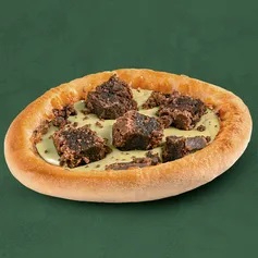 Massa de esfiha recheada com creme de pistache e finalizada com cubos de brownie, que adicionam um sabor doce e textura macia.