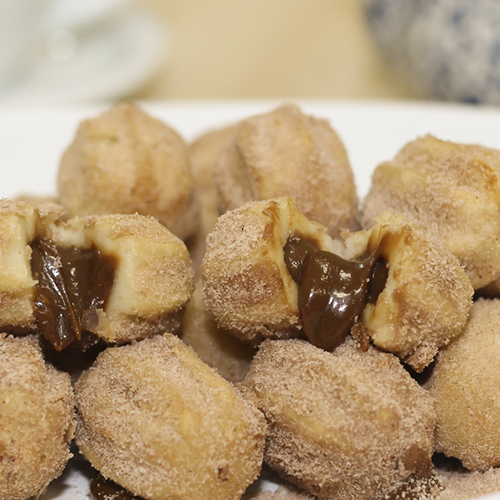 Deliciosos mini churros crocantes , recheados com chocolate e polvilhados no açucar e canela.