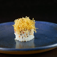 Alga, arroz japonês, gergelim. Recheio: salmão grelhado. Por cima: cream cheese e alho poro crispy.