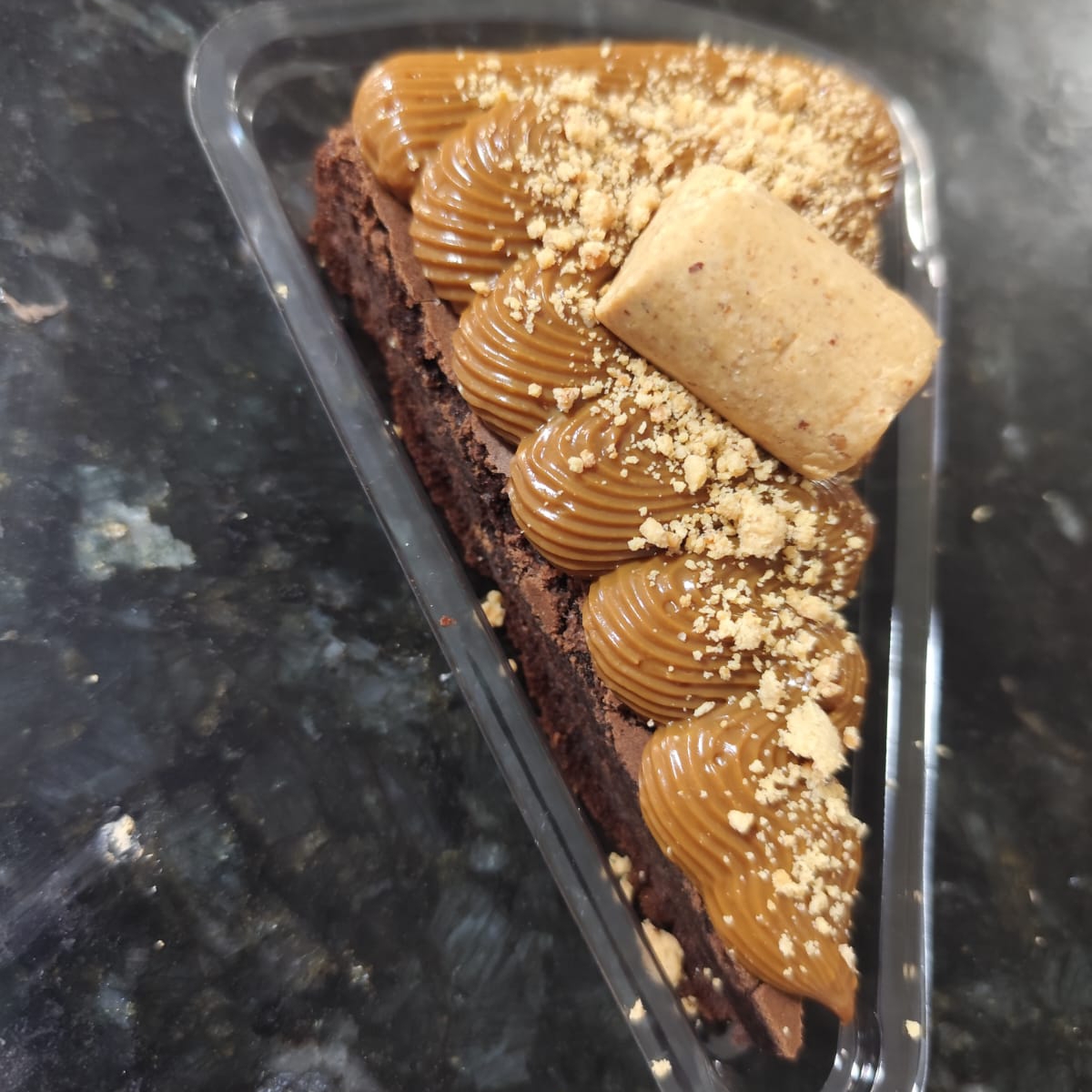 Fatia do nosso brownie com uma massa bem chocolatuda e uma leve casquinha crocante por fora. Generosa cobertura de doce de leite cozido na panela de pressão e finalizado com paçoca.