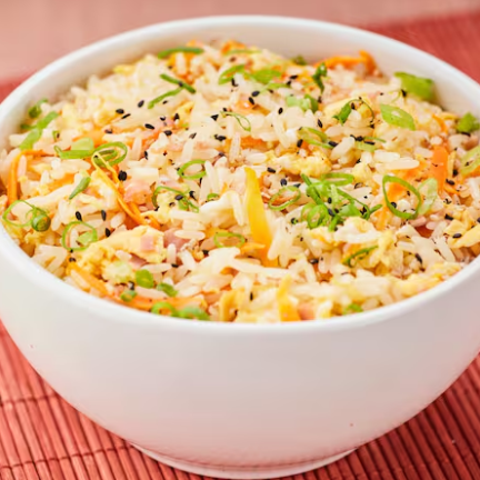 Uma combinação irresistível de arroz frito com ovos mexidos, presunto, cenoura e cebolinha.