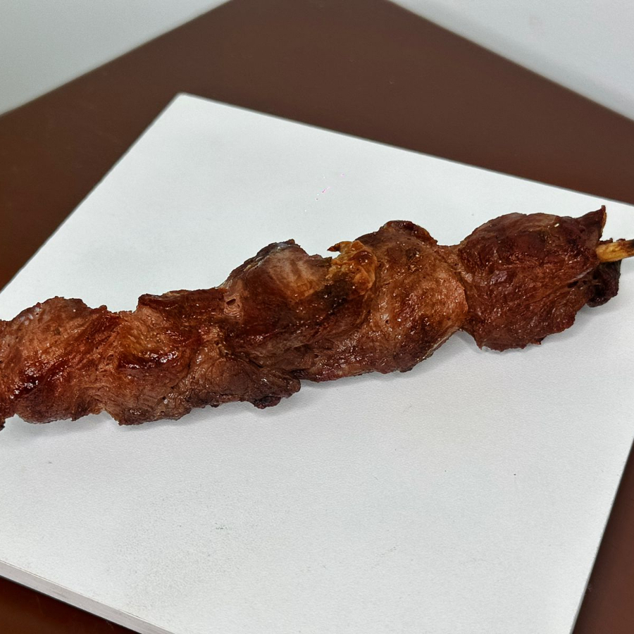 Delicioso espetinho de carne assado.