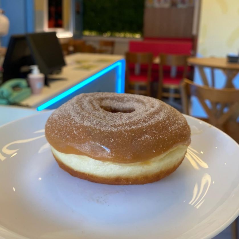 Donut fresquinho e fofinho com cobertura de Doce de leite com Açúcar e Canela.