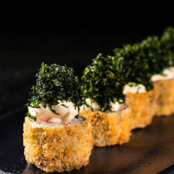 Salmão grelhado envolto em arroz e finalizado com crispy de couve por cima, trazendo uma combinação perfeita de sabor, leveza e crocância.