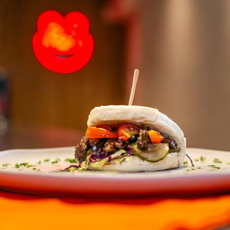 O Sea Beef Bao é uma fusão sofisticada de sabores terrosos e marítimos, combinando carne suculenta com um toque umami do molho de ostras, tudo envolto em um pão bao macio e levemente adocicado. Ingredientes: Pão bao macio e cozido no vapor, proporcionando leveza à combinação. Carne de boi suculenta e bem temperada, trazendo um sabor rico e marcante. Salada crocante, que adiciona frescor e textura ao conjunto. Tomatinhos frescos, equilibrando os sabores com um toque levemente adocicado e ácido. Mix de gergelim branco e preto, oferecendo um toque tostado e sofisticado. Molho de ostras, encorpado e levemente adocicado, com umami intenso que realça o sabor da carne. O Sea Beef Bao une a robustez da carne bovina com a profundidade do molho de ostras, criando uma experiência gastronômica única, equilibrada e cheia de sabor!