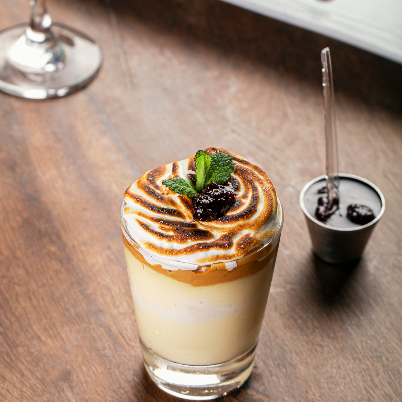 Pão de ló embebido em creme de tres leches, doce de leite e calda de frutas vermelhas.