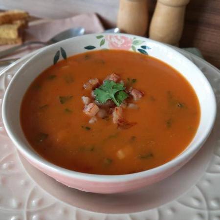 Nosso Caldo de Abóbora é preparado com a doçura natural da abóbora, que se transforma em uma base aveludada e reconfortante. Para quebrar a doçura e adicionar um toque especial, a sopa recebe um toque defumado e picante com a adição de bacon crocante e calabresa triturada. O nosso tempero caseiro exclusivo realça todos os sabores, e um toque de coentro fresco traz um frescor que eleva o prato a outro nível. Servido com um pãozinho, é a opção perfeita para quem busca uma refeição farta e cheia de personalidade.