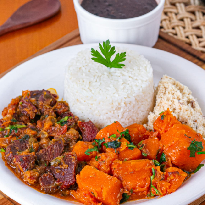 Marmitex Premium do Dia: Carne Seca com Abóbora. Uma refeição saborosa e única, trazendo a carne seca temperada com a especialidade da casa, aliada à abóbora cortada em cubos primorosos. Acompanha arroz branco soltinho, feijão ricamente temperado e a irresistível farofa da casa. Uma tradição nordestina deliciosa, servida generosamente em uma marmitex com aproximadamente 600gr, perfeita para satisfazer plenamente uma pessoa. Uma sugestão do chef que é a estrela dos nossos pratos premium.
