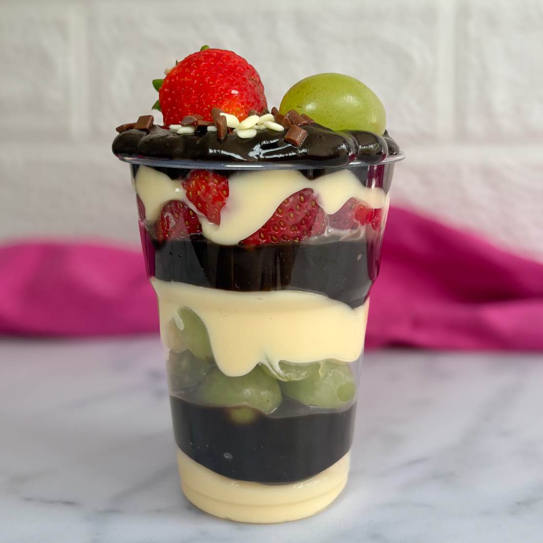 Três camadas de brigadeiro 2 amores (Ninho e chocolate preto) com uvas e morangos frescos.