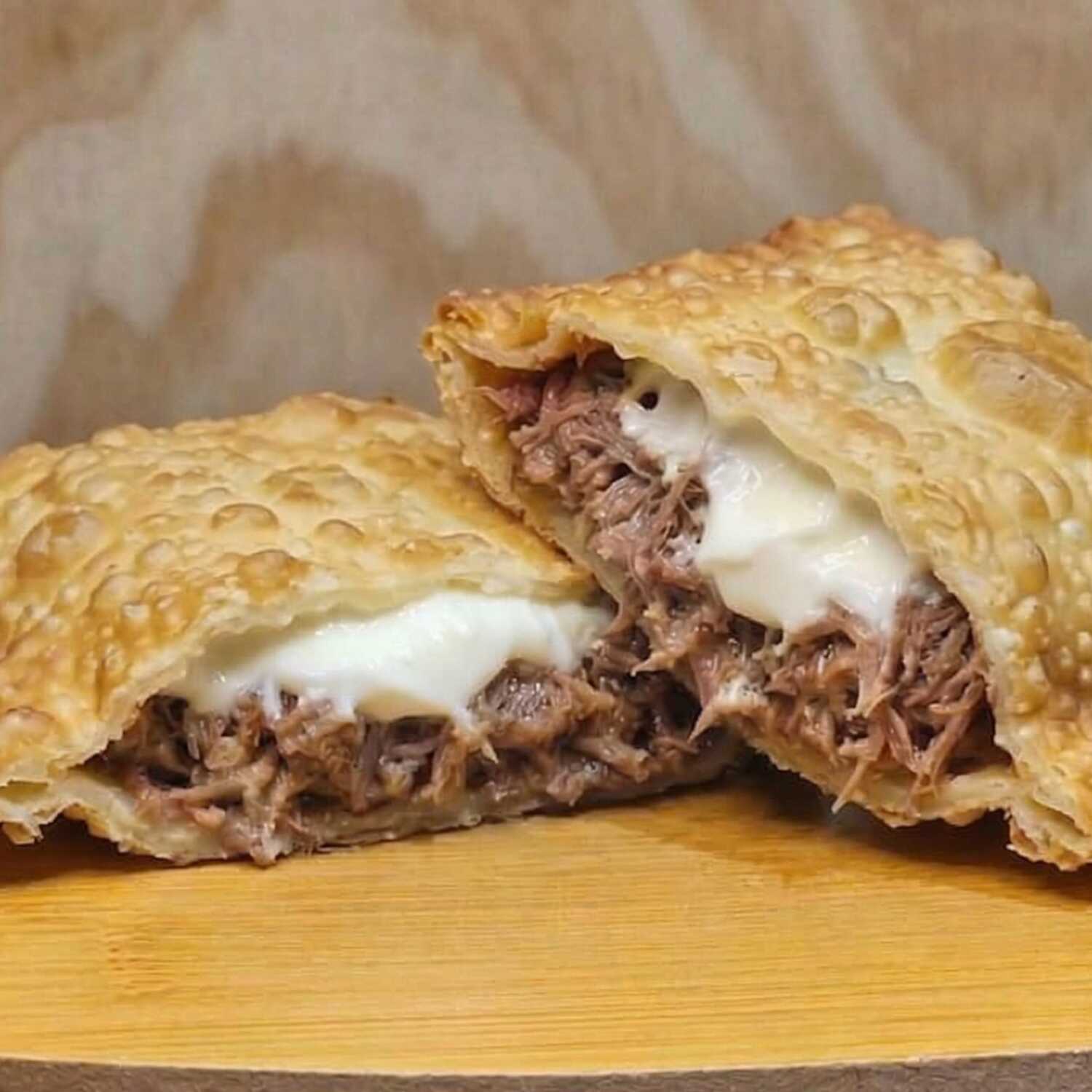 Delicioso pastel recheado com costelinha suculenta, cream cheese cremoso e molho barbecue, uma explosão de sabor irresistível.