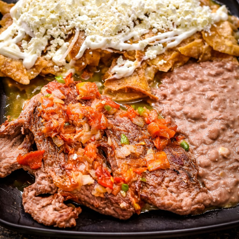 Bistec a la mexicana con chilaquiles y frijoles