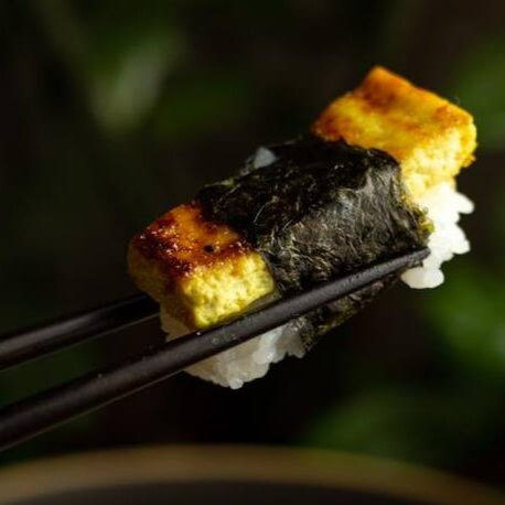 Tofu ao curry com tarê selado na chapa, sobre arroz temperado e envolto por alga nori. Aromático e delicado.