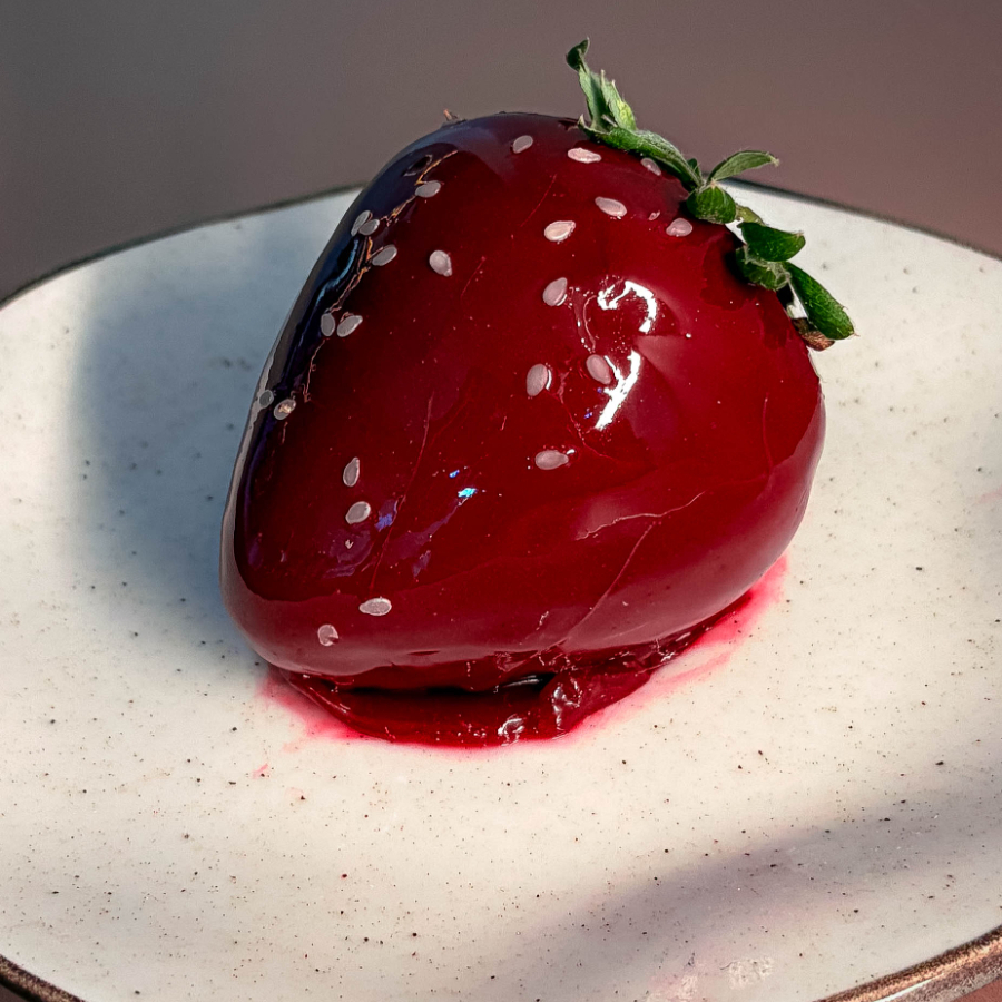 Gelado e cremoso com a aparência de um morango, feito 4 camadas únicas. Entremets são doces feitos em diversas camadas, normalmente com aparências lindas e especiais. O entremet de morango, além de estético, possui um sabor bem equilibrado, e com muito morango e chocolate. Textura alterna entre cremoso e crocante. Detalhes sobre as camadas: Externamente muito cremoso devido a glaçagem brilhante, seguido pelo crocante da fina enrobage de chocolate meio amargo, e então a ganache de morango, que preenche grande parte do doce, e em seu interior, um recheio abundante de morangos frescos picados e cremoso de morango levemente citrico. Aprox: 140g (quase o tamanho de uma maçã)