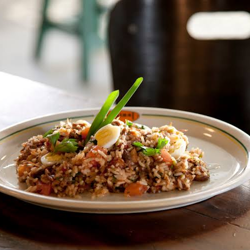 Arroz com Rabada Desfiada e Agrião Rabada desfiada, refogada com tempero caseiro e finalizada com agrião fresco, servida sobre arroz soltinho. Um prato completo, saboroso e bem servido — ideal para até duas pessoas. Uma explosão de sabor em cada garfada! Porção com aproximadamente 600g.