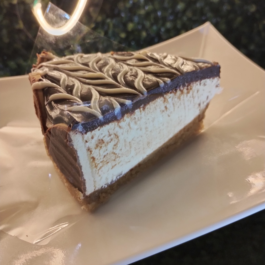 Base de biscoito, recheada com creme holandês e com cobertura de creme de chocolate e biscoitos cobertos com chocolate.