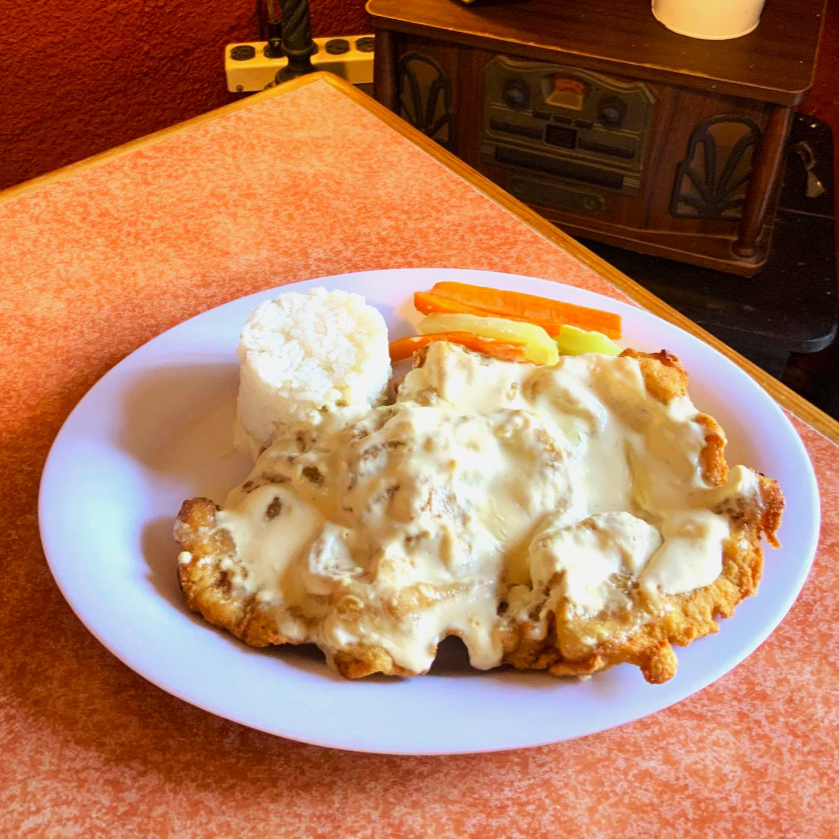 Milanesa de pollo bañado en salsa de queso