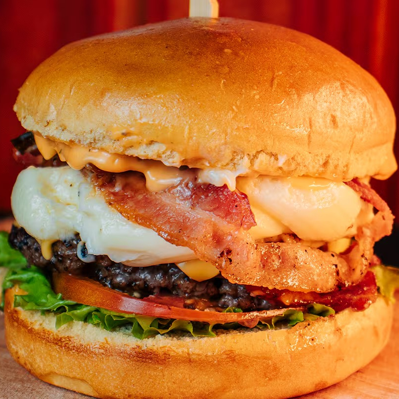 Black Catupiry Burger feito com hambúrguer de 150g suculento, molho da casa, alface fresca, tomate, cebola roxa, bacon crocante e o irresistível Catupiry Original. Uma combinação cremosa e cheia de sabor em cada mordida!