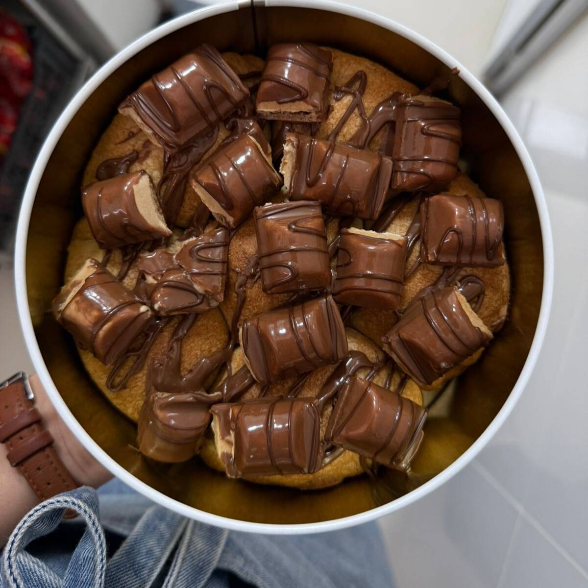 Torta na lata com aproximadamente 600g feita com cookie de massa branca com recheio de creme de Kinder bueno branco, finalizado com Nutella e Kinder bueno. Recomendo Fortissimo Um Gelato De Leite.