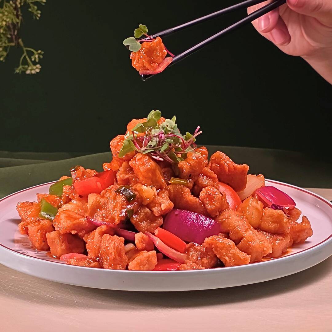 Frango empanado, salteado no wok e glaceado com molho agridoce, abacaxi e pimentões.