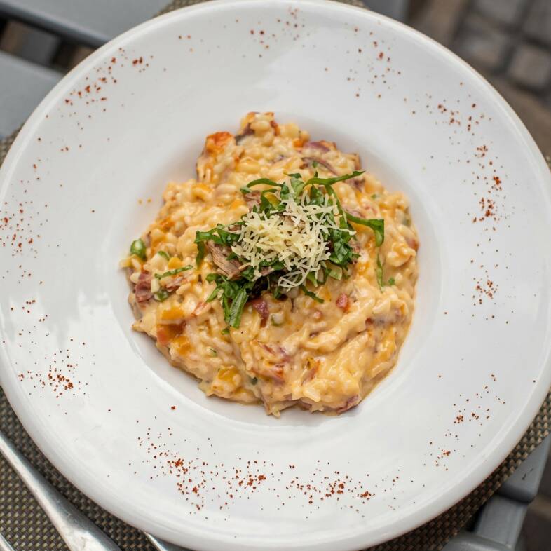 Risoto de Costela Desfiada | Risoto cremoso preparado com costela desfiada, macia e saborosa, servido com tomates-cereja. Uma combinação de cremosidade e sabor marcante, com o toque especial da cozinha do Becco.