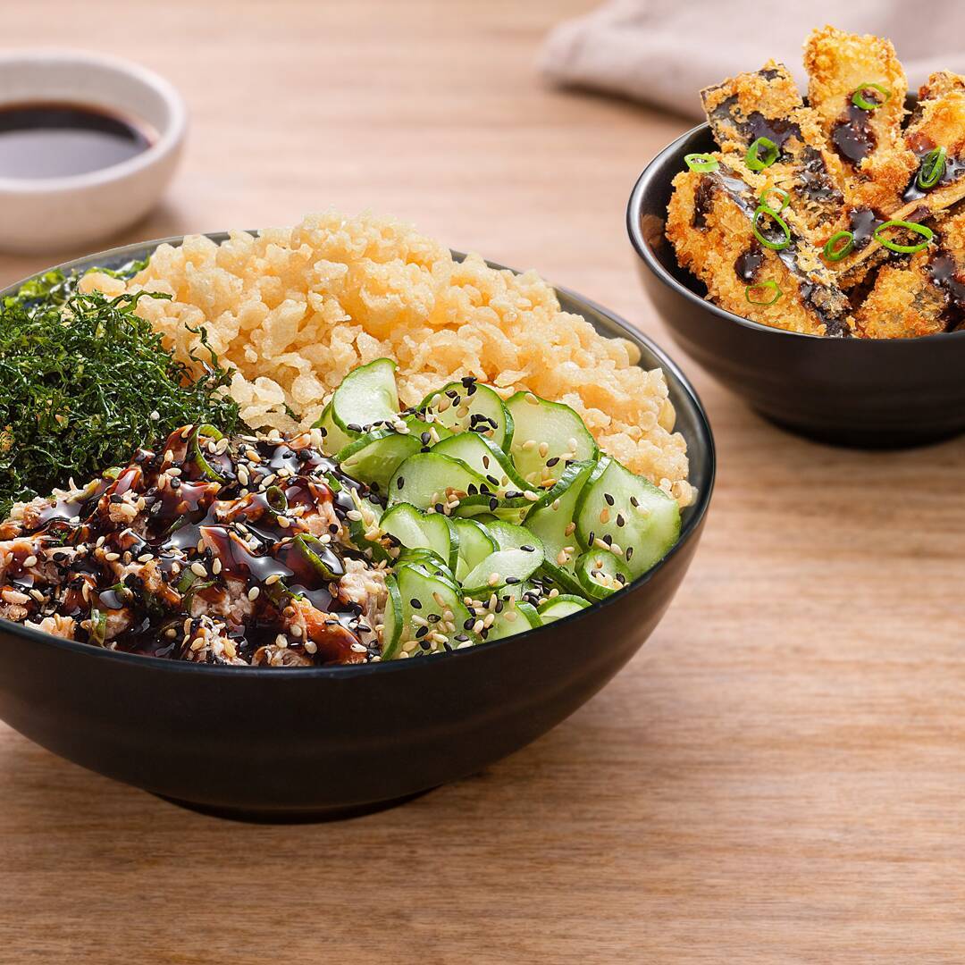 Poke com arroz de sushi, salmão grelhado e desfiado misturado com cream cheese e cebolinha, coberto com molho tarê, sunomono, couve crispy, crispy de tempurá e gergelim, acompanhado de 5 unidades de berinjela empanada com farinha crocante, molho tonkatsu e cebolinha