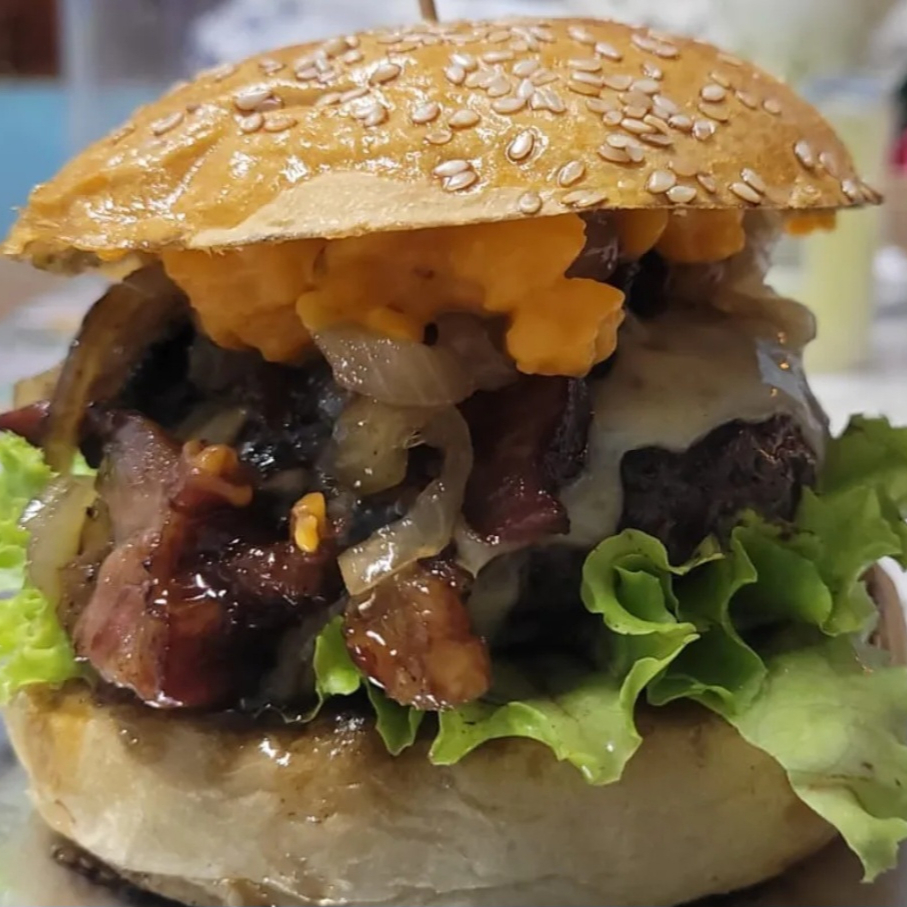 Peça nosso delicioso Dama da Casa: Pão gergelim, blend 160gr, queijo, creme cheddar da casa, bacon, cebola caramelizada, alface e tomate.