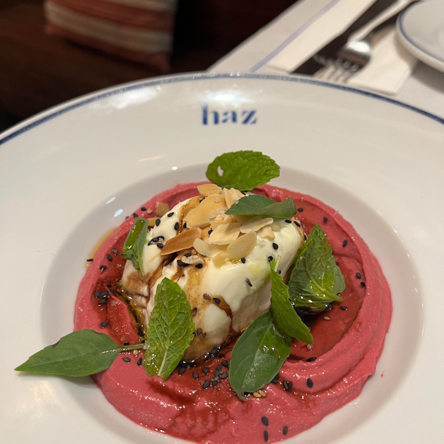 Burrata, homus rosa, lâminas de amêndoas crocantes, ervas frescas e melaço de romã