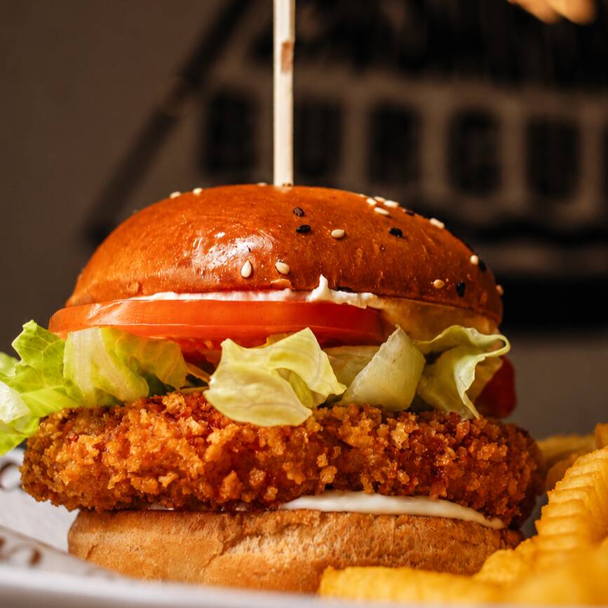 Pão, burger de frango, queijo defumado, alface americana, tomate e maionese da casa.