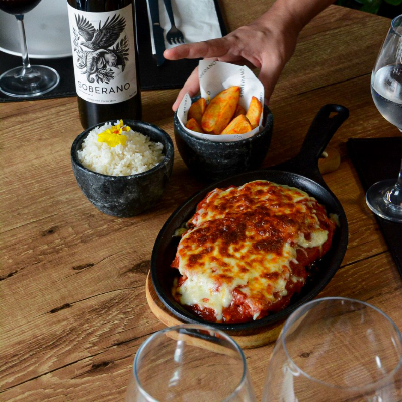 Suculento bife à parmegiana, arroz, batata rústica.