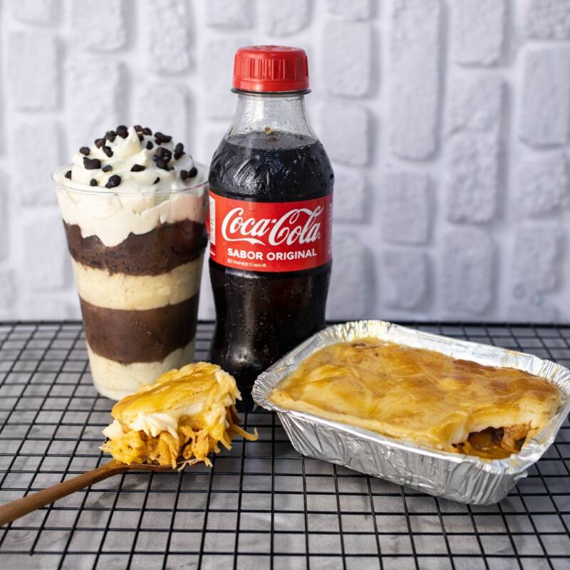 Se conforto tivesse sabor, provavelmente seria um desses empadões. Recheio generoso — pode ser frango bem molhadinho com Catupiry Original ou camarão cremoso — envolvido por uma massa leve que praticamente derrete na boca. E pra completar, acompanha refri geladinho e um doce tão equilibrado que até quem diz “não sou muito de doce” muda de ideia na primeira colherada.