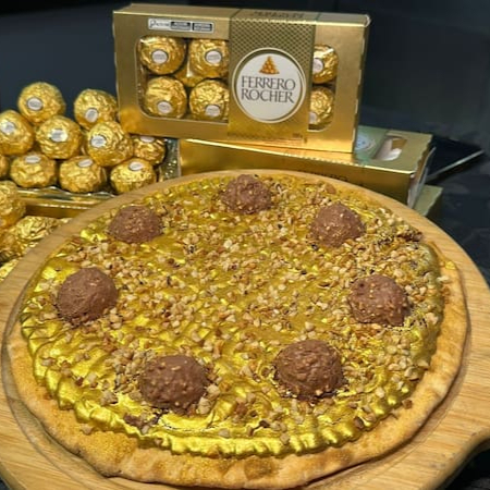 Chocolate Nestlé com cobertura dourada, castanhas e deliciosos bombons Ferrero Rocher sob uma massa fininha e crocante. (Aprox 24cm)