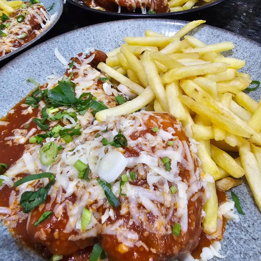 Filé de Frango à Parmegiana, um dos mais pedidos do Rosário! Este prato traz um suculento filé de frango primorosamente empanado e gratinado com o mais saboroso queijo. Para tornar a sua experiência ainda mais prazerosa, oferecemos uma variedade de acompanhamentos à sua escolha: Um arroz soltinho, o tradicional feijão brasileiro, macarrão, farofa crocante, batatas fritas douradas, uma refrescante salada verde ou nutritivos legumes frescos. Nosso desejo é que você desfrute de uma experiência gastronômica incrível conosco!