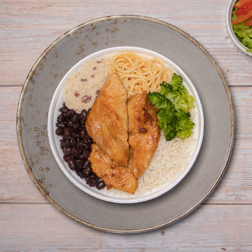 Peito de frango grelhado, arroz, feijão preto, macarrão, farofa e acompanhamento do Dia.