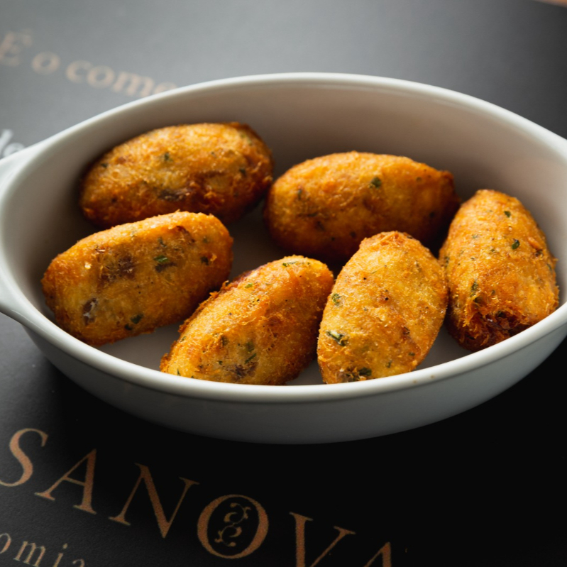 Bacalhau desfiado, purê de batata, ovo e salsa.