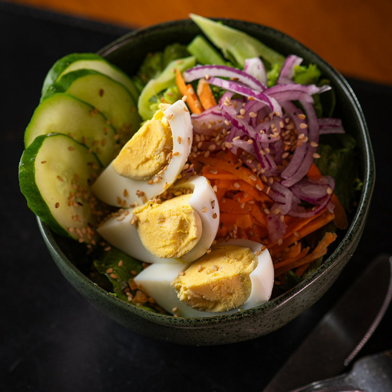 Arroz integral, brócolis, cenoura, pepino, ovos cozidos, gergelim, crispy de cebola e molho da casa.