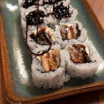 Rolo de sushi com arroz por fora, recheio de Skin ( pele de salmão frita ) e cream Cheese e arroz, finalizado com gergelim por fora.